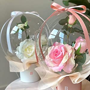 A photo of the balloon in a bouquet being given to someone.