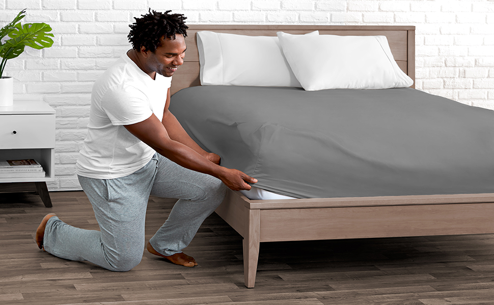 A person putting a Fitted Sheet on a Mattress