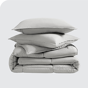 Folded comforter with pillow stacked on top