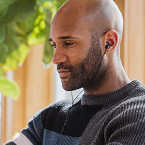 african american man listening to music wearing corded black earbuds