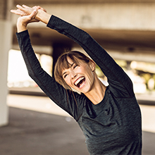 Happy woman working out; Always Discreet features LeakGuards so you can exercise with confidence.